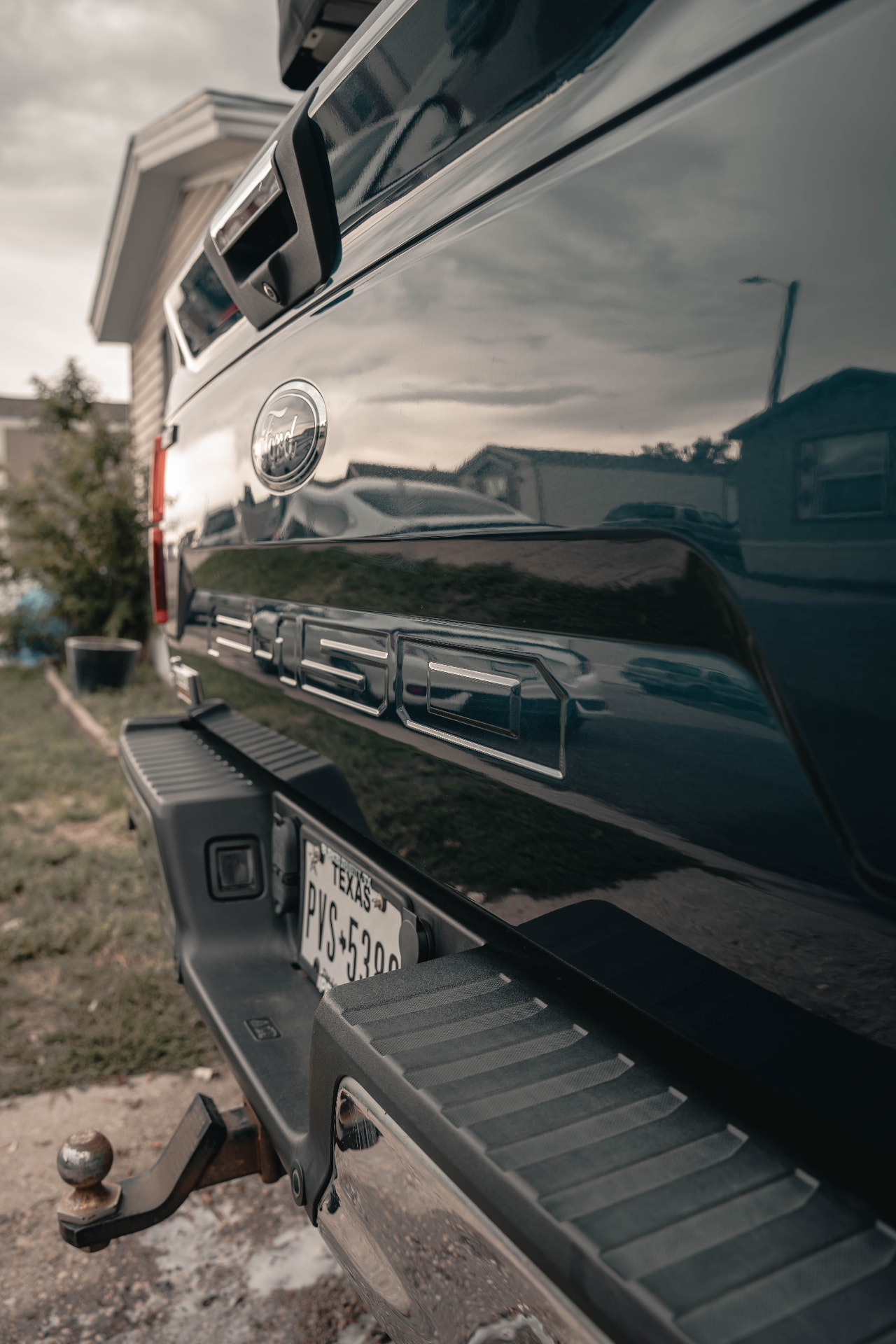 Glossy black Ford F-150 tailgate reflecting the sky after a paint detail